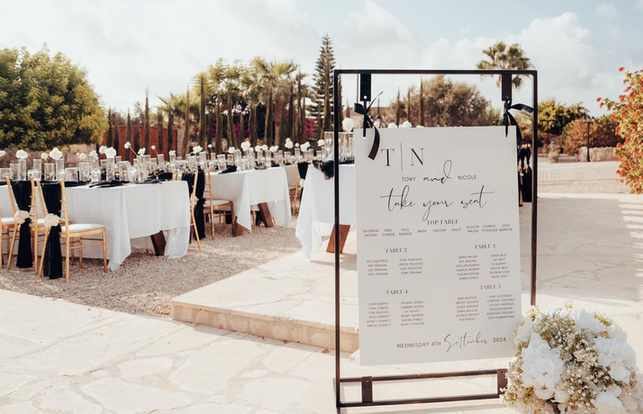 Black Ribbon Tied Table Plan Complete with Flower Arrangement and Candles